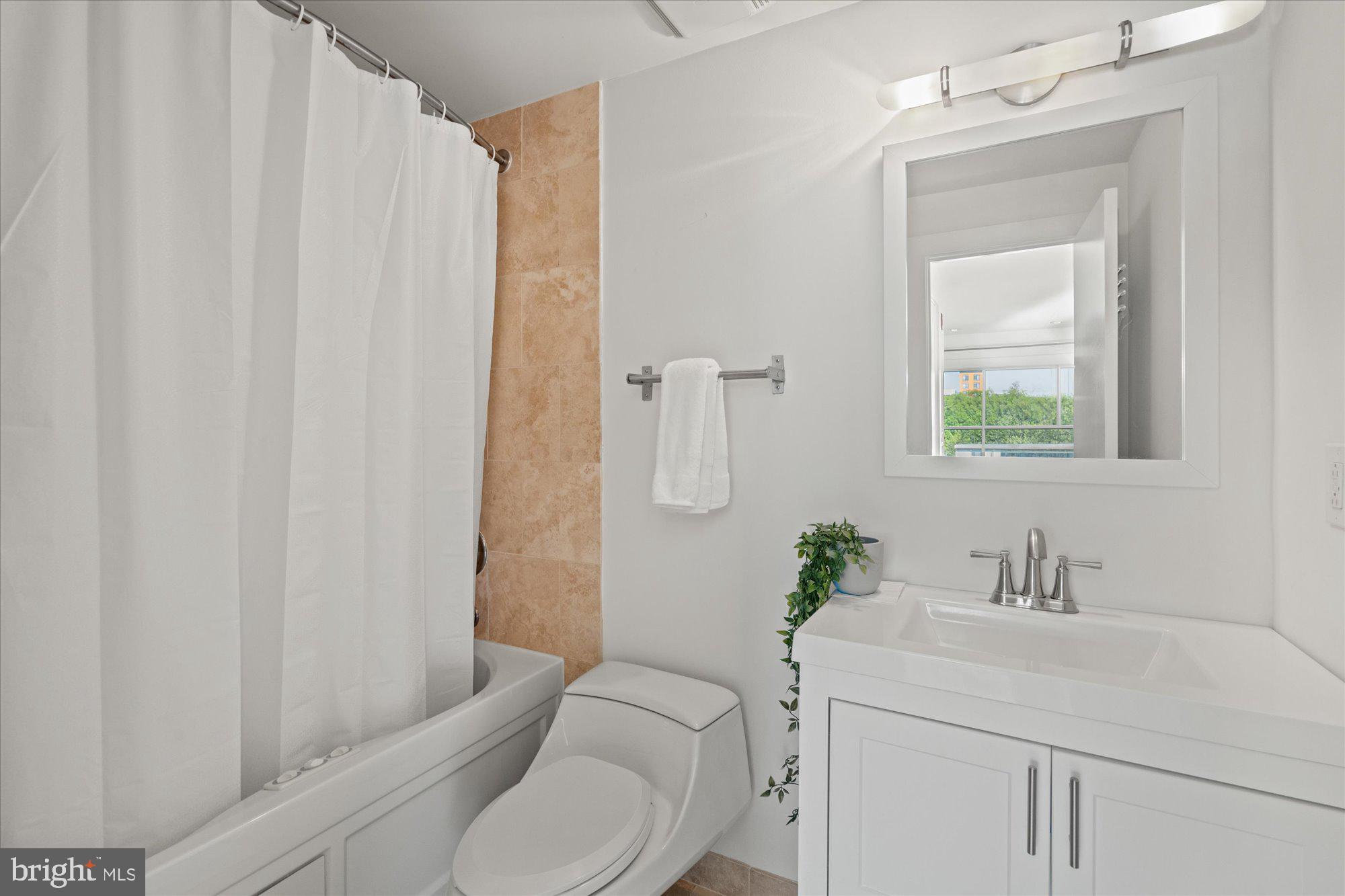 449 R Street Northwest, Unit 301 Washington, DC 20001 - Photo 20 of 37 a bathroom with a sink a toilet and shower curtain