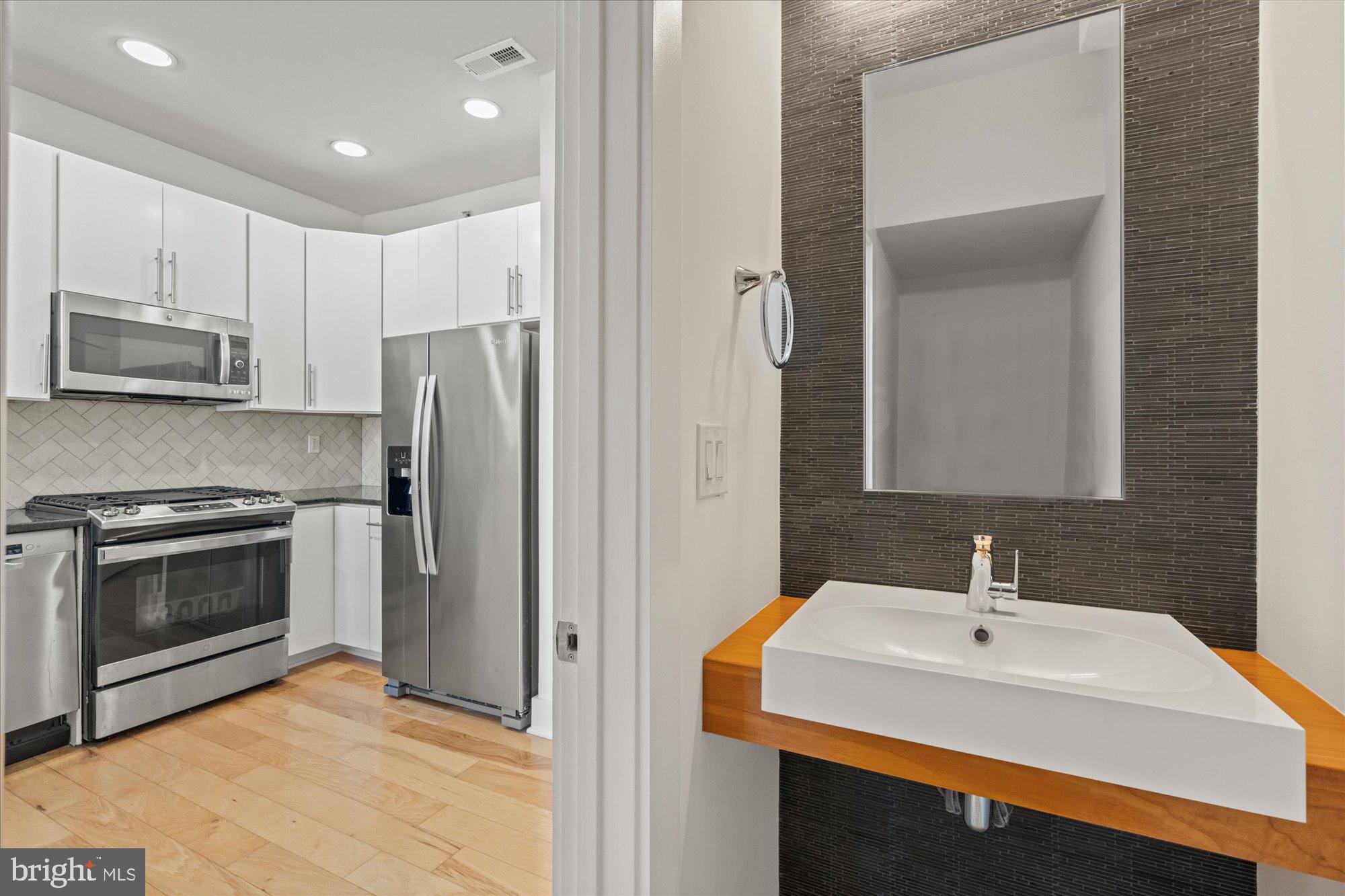 449 R Street Northwest, Unit 301 Washington, DC 20001 - Photo 5 of 37 a kitchen with stainless steel appliances a stove sink and microwave