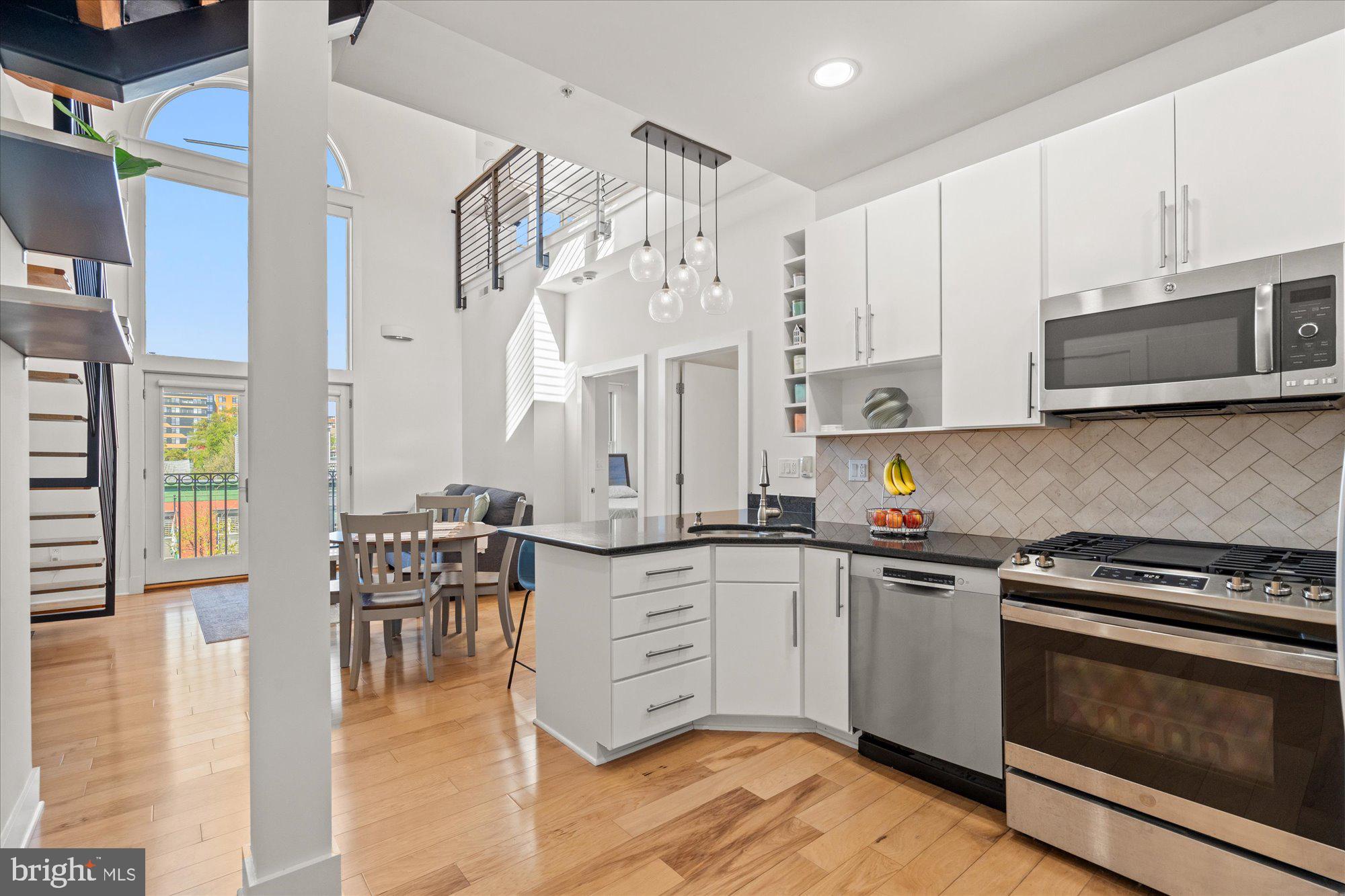 449 R Street Northwest, Unit 301 Washington, DC 20001 - Photo 7 of 37 a kitchen with granite countertop a stove top oven microwave and cabinets