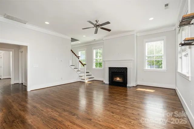 a large kitchen with granite countertop a stove a sink a center island and wooden floor