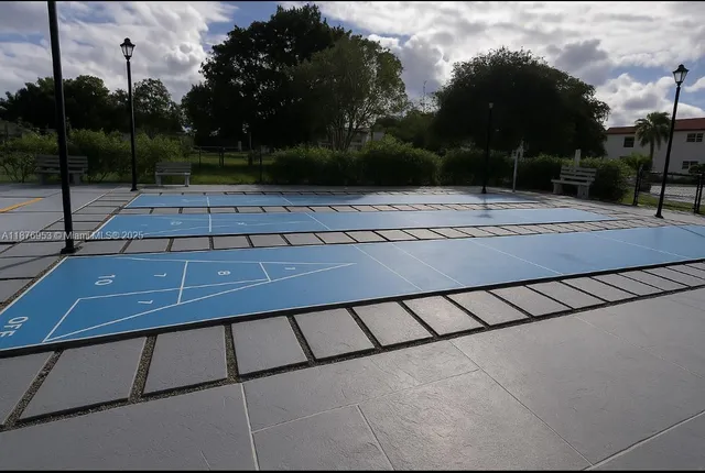 a view of a swimming pool with lawn chairs and plants