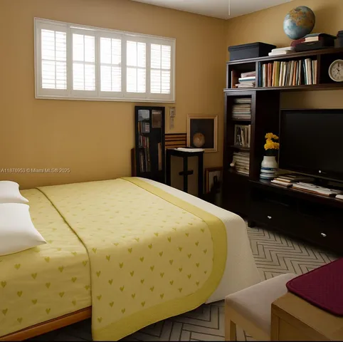 a bedroom with a bed and a television
