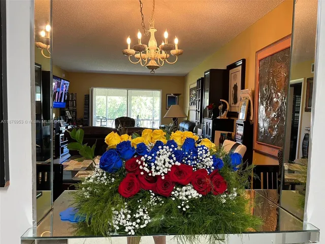 a room with lots of flowers and chandelier