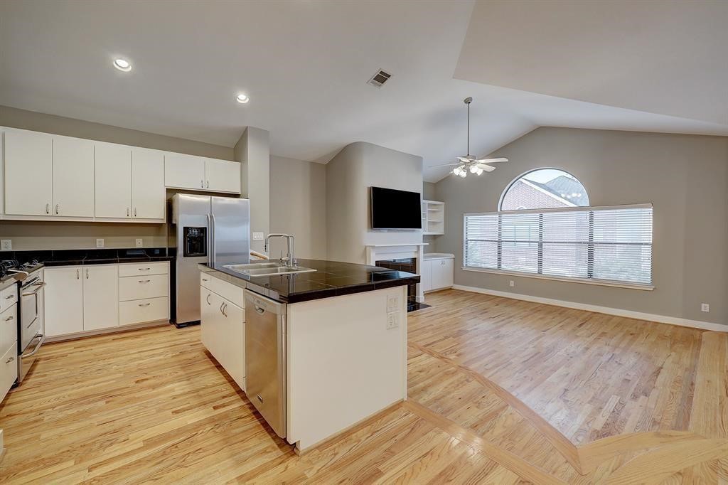 a kitchen with granite countertop a stove and a wooden floors