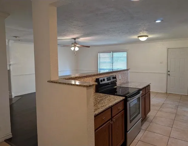 a kitchen with granite countertop a sink and a stove