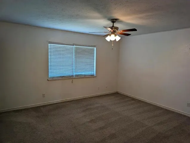 a view of a livingroom with a ceiling fan and window