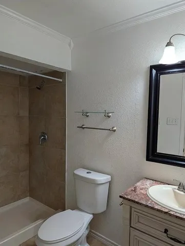 a bathroom with a granite countertop toilet sink and shower