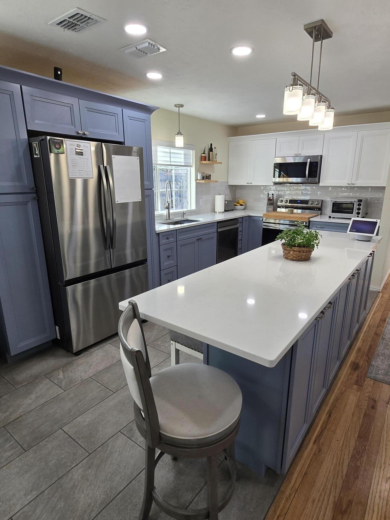 a kitchen with refrigerator and chairs
