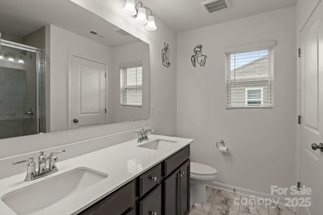 a bathroom with a granite countertop sink a toilet and a mirror