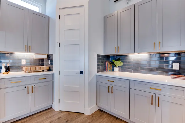 a kitchen with stainless steel appliances granite countertop a stove and white cabinets