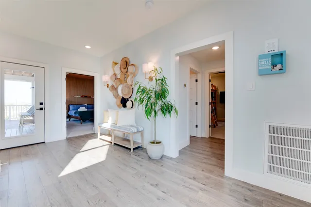 a view of a hallway with wooden floor and a living room