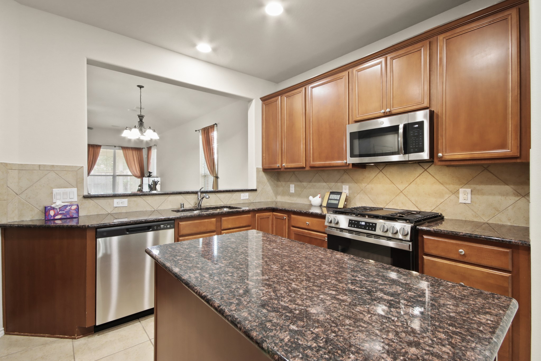 16918 Cherokee Lake Lane Houston, TX 77044 - Photo 7 of 35 a kitchen with stainless steel appliances granite countertop a sink stove and microwave