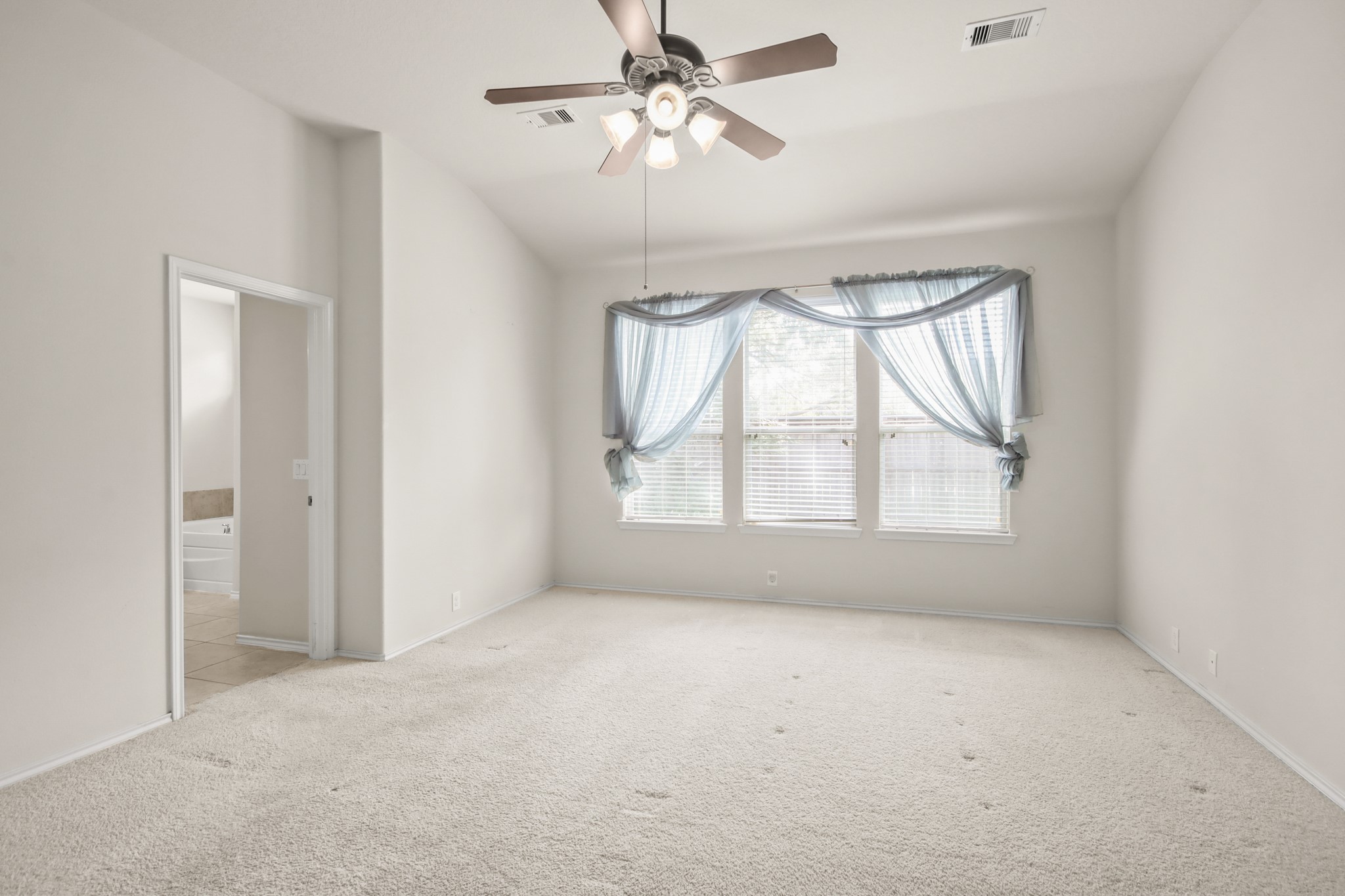 16918 Cherokee Lake Lane Houston, TX 77044 - Photo 10 of 35 an empty room with a window and a chandelier fan