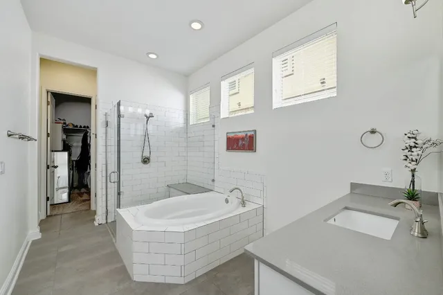 a bathroom with a tub sink and mirror