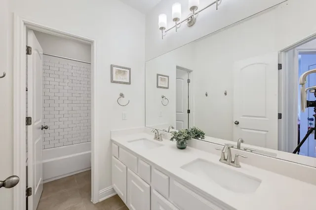 a bathroom with a double vanity sink mirror and shower