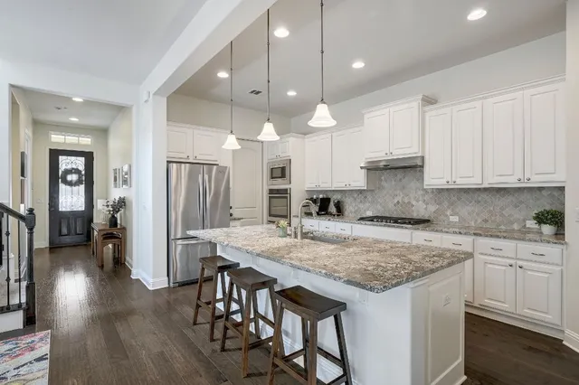 a kitchen with a center island appliances and cabinets