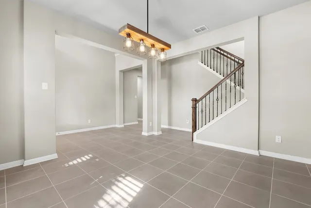 a view of a hallway with stairs and a window