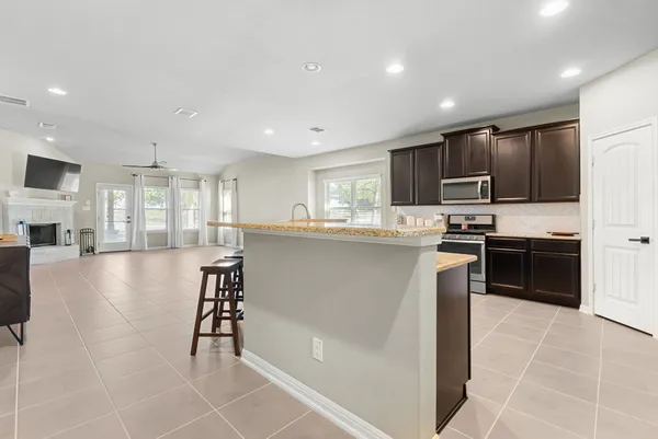 a kitchen with stainless steel appliances granite countertop a refrigerator and a stove top oven