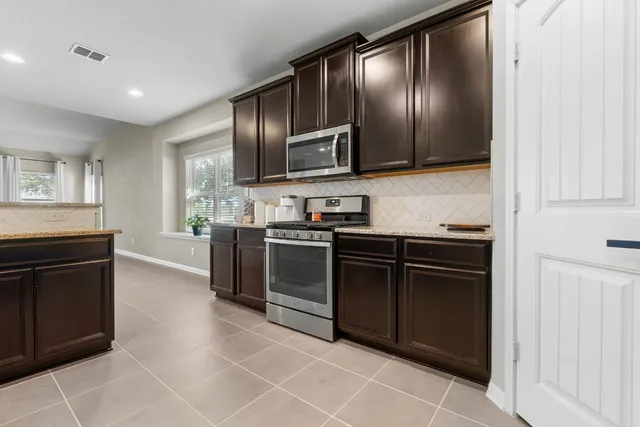 a kitchen with granite countertop stainless steel appliances and cabinets