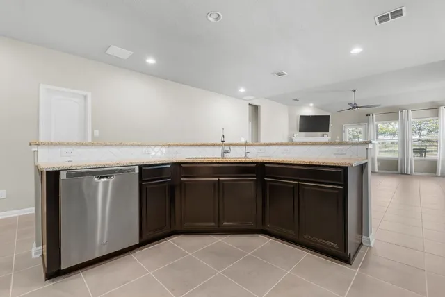 a kitchen with stainless steel appliances granite countertop a refrigerator and a sink