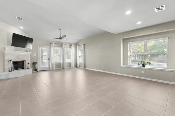 a view of an empty room with a fireplace and a window