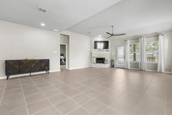 a view of an empty room with a fireplace and a window