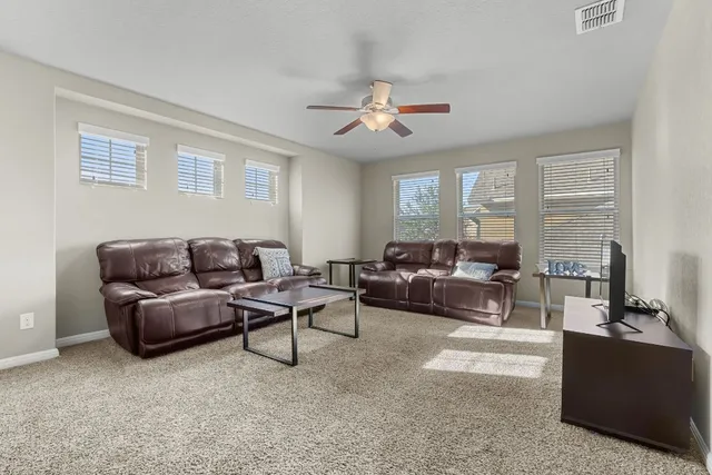 a living room with furniture and a ceiling fan