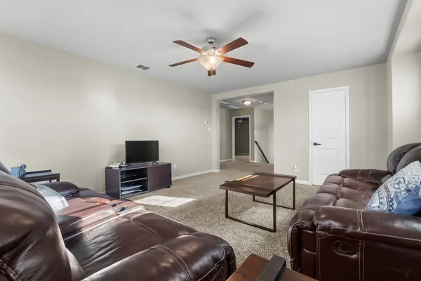 a living room with furniture and a ceiling fan