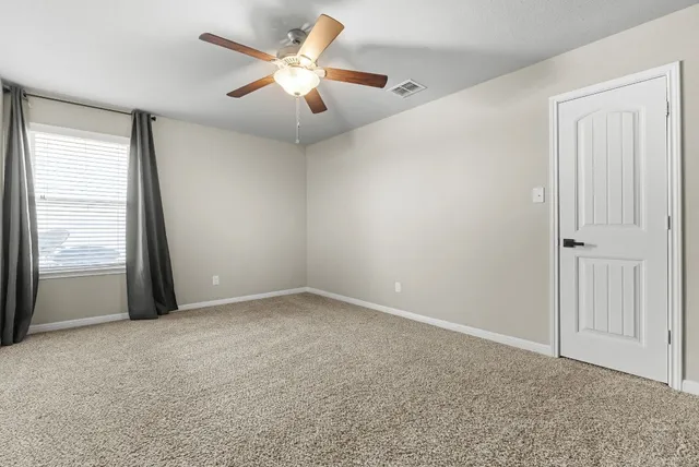 an empty room with closet and ceiling fan