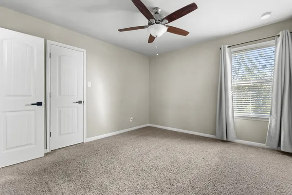 a view of an empty room with a ceiling fan