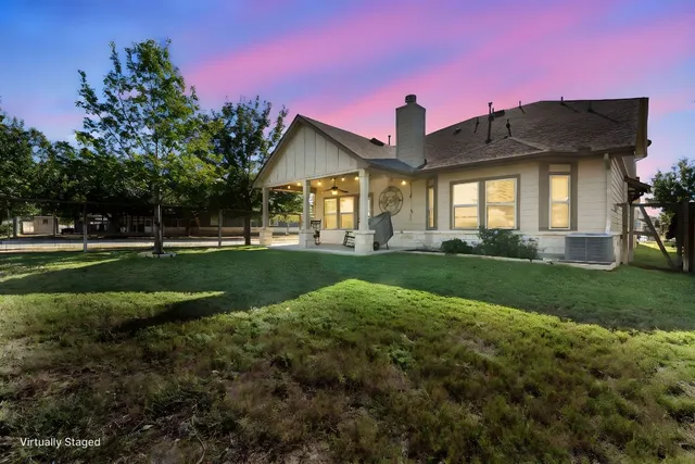a front view of a house with a yard and potted plants