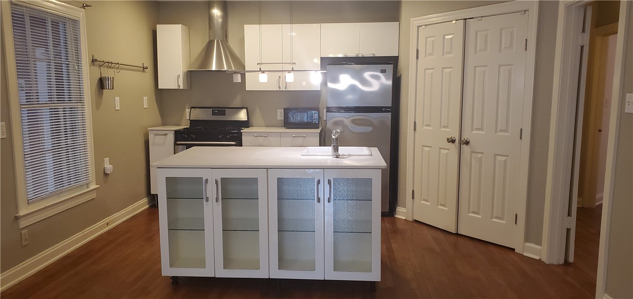 406 East Monroe Street, Unit A Austin, TX 78704 - Photo 20 of 35 a kitchen with stainless steel appliances granite countertop a stove a sink and a refrigerator with wooden floor