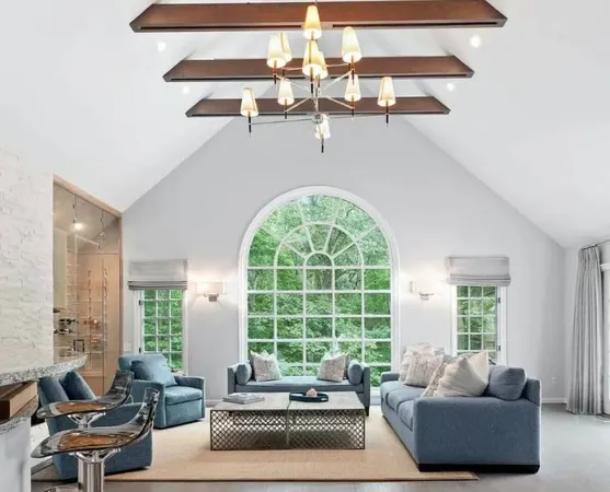 a living room with furniture and floor to ceiling windows