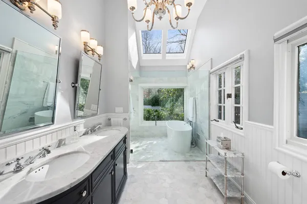 a spacious bathroom with a tub sink and mirror