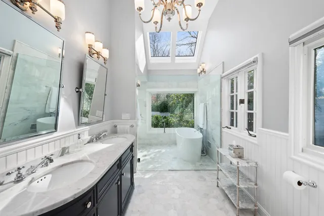 a spacious bathroom with a tub sink and mirror