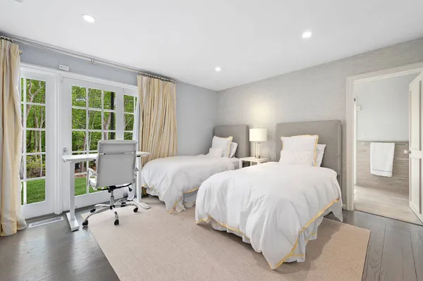 a bedroom with two beds and a large window