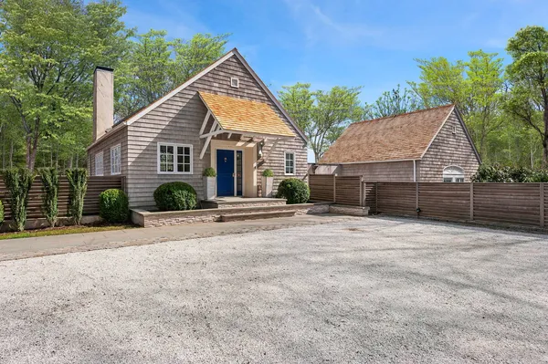 a view of a house with a yard and potted plants