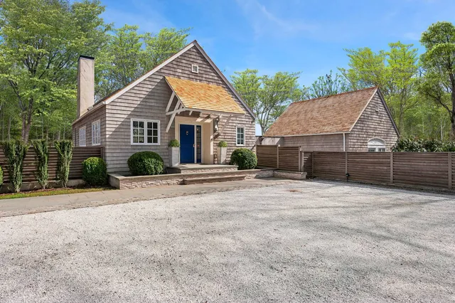 a view of a house with a yard and potted plants
