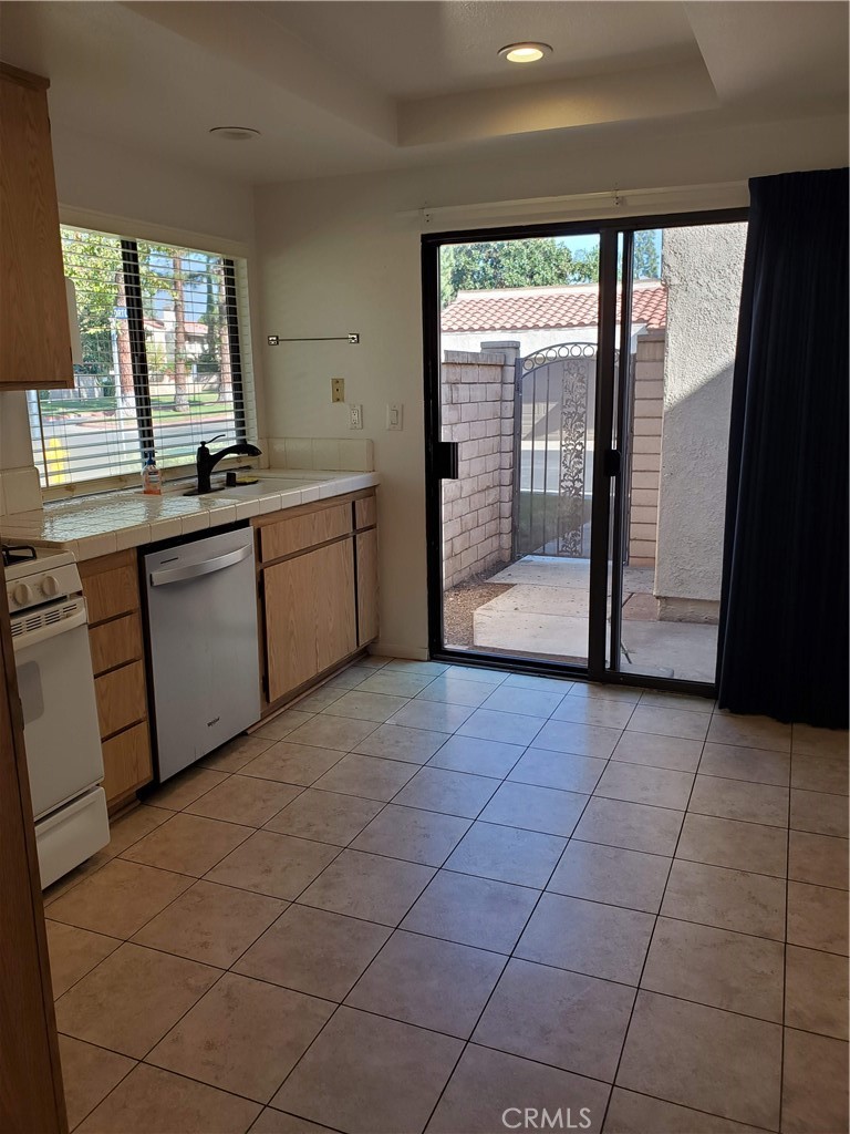 7864 Portola Road Rancho Cucamonga, CA 91730 - Photo 17 of 37 a large white kitchen with a large window