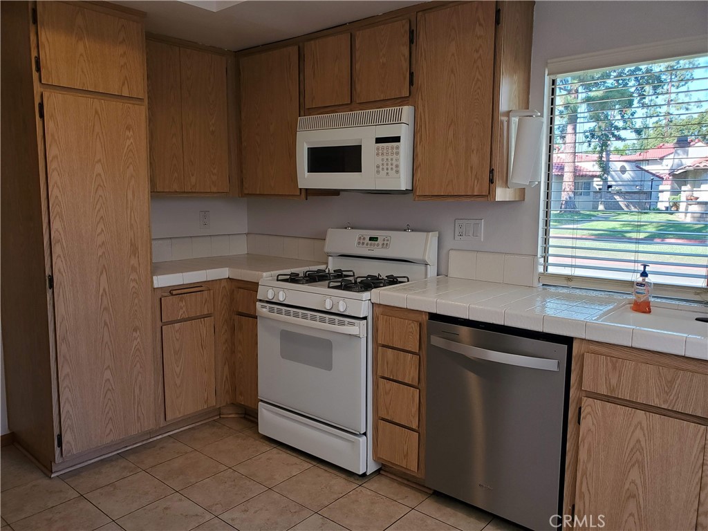 7864 Portola Road Rancho Cucamonga, CA 91730 - Photo 19 of 37 a kitchen with cabinets appliances and a window