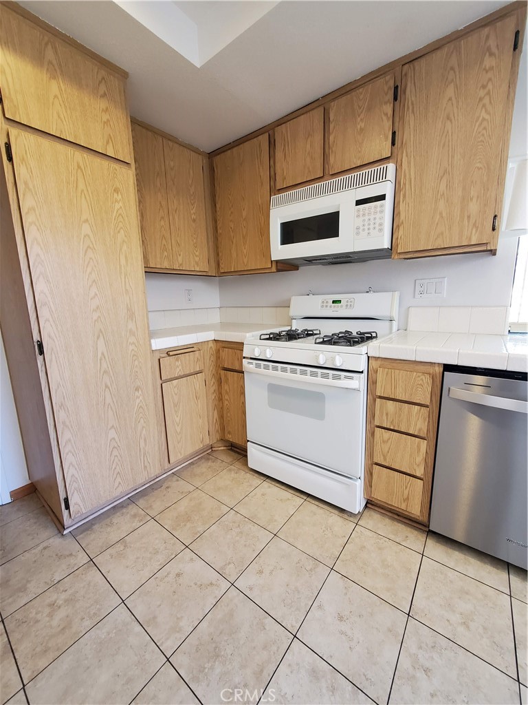 7864 Portola Road Rancho Cucamonga, CA 91730 - Photo 21 of 37 a kitchen with a stove a sink and a microwave