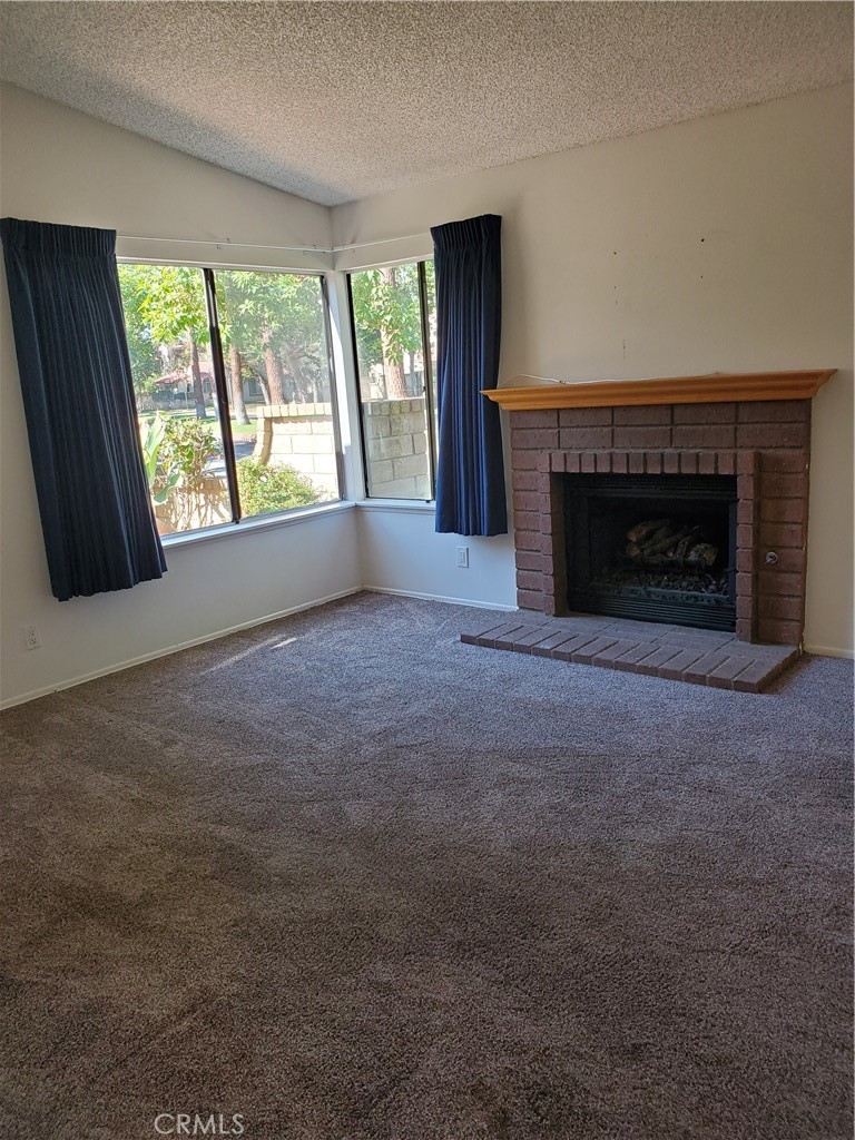 7864 Portola Road Rancho Cucamonga, CA 91730 - Photo 4 of 37 an empty room with windows and fireplace