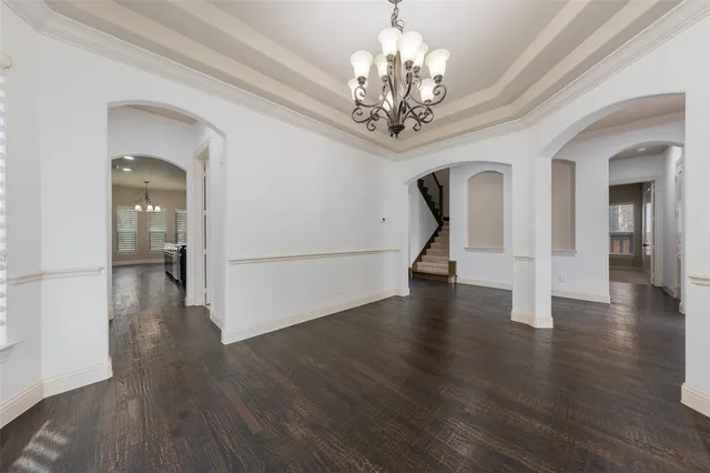 a view of a room with wooden floor chandelier and entryway
