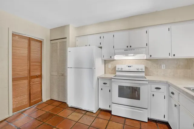 a white refrigerator freezer and a stove in a kitchen