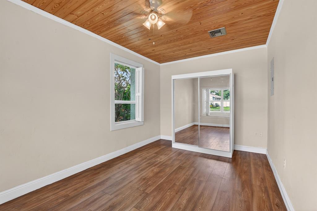 501 Northwest 54th Street Boca Raton, FL 33487 - Photo 12 of 43 an empty room with wooden floor chandelier and windows