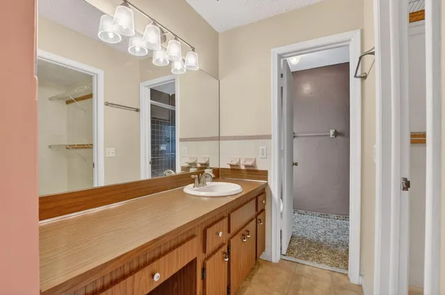 a spacious bathroom with a granite countertop sink and a mirror