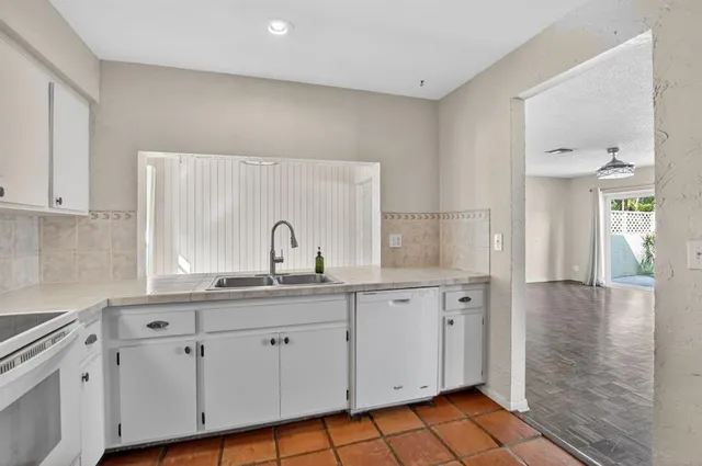 a kitchen with white cabinets appliances and a sink