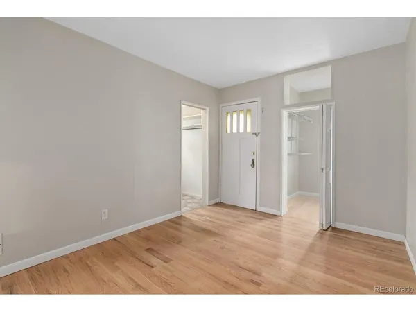 a view of an empty room with wooden floor