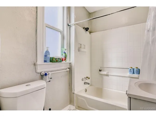 a bathroom with a sink a mirror a toilet and shower