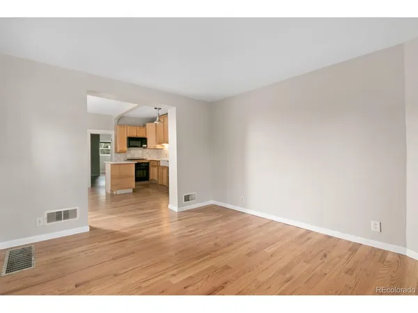 a view of empty room with kitchen and window